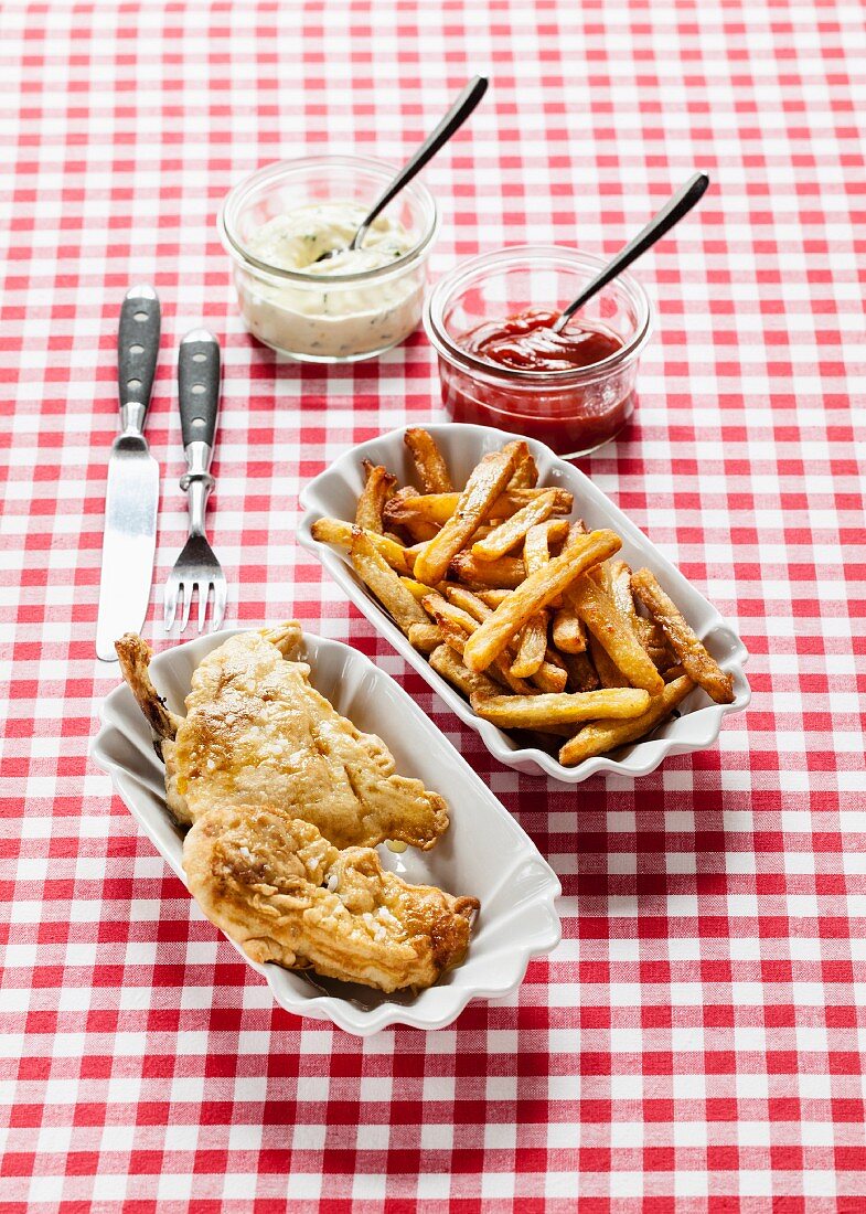 Fried chicken with chips, ketchup and remoulade on a checked tablecloth