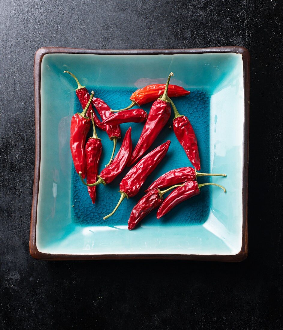 Dried red chilli peppers in a turquoise bowl