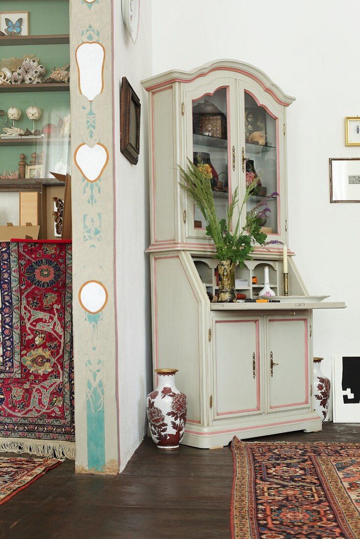 Antique corner cabinet next to painted doorway