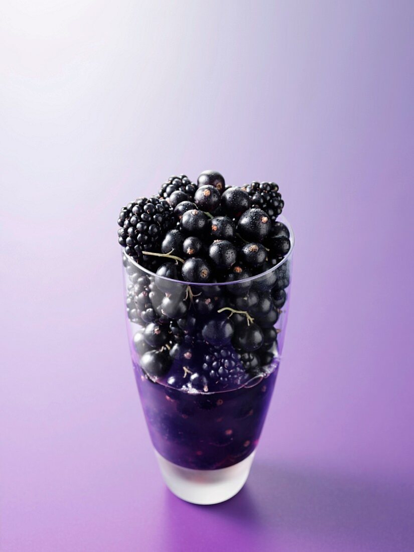 Ingredients for fruit juice made from black currants and blackberries in a glass
