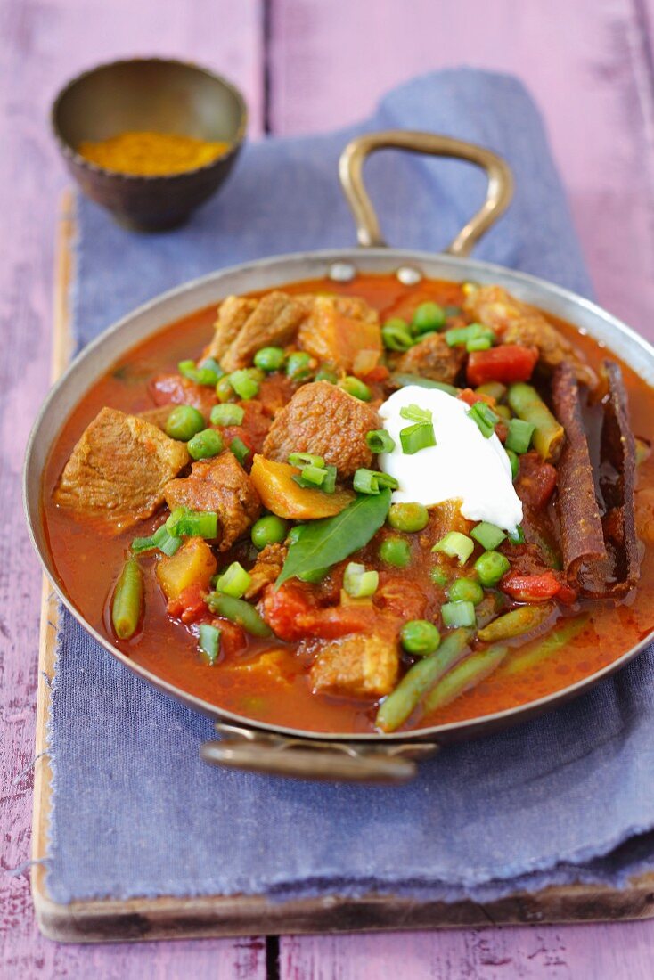 Schweinenacken-Curry mit Tomaten, Mango, grünen Bohnen, Erbsen und Joghurt