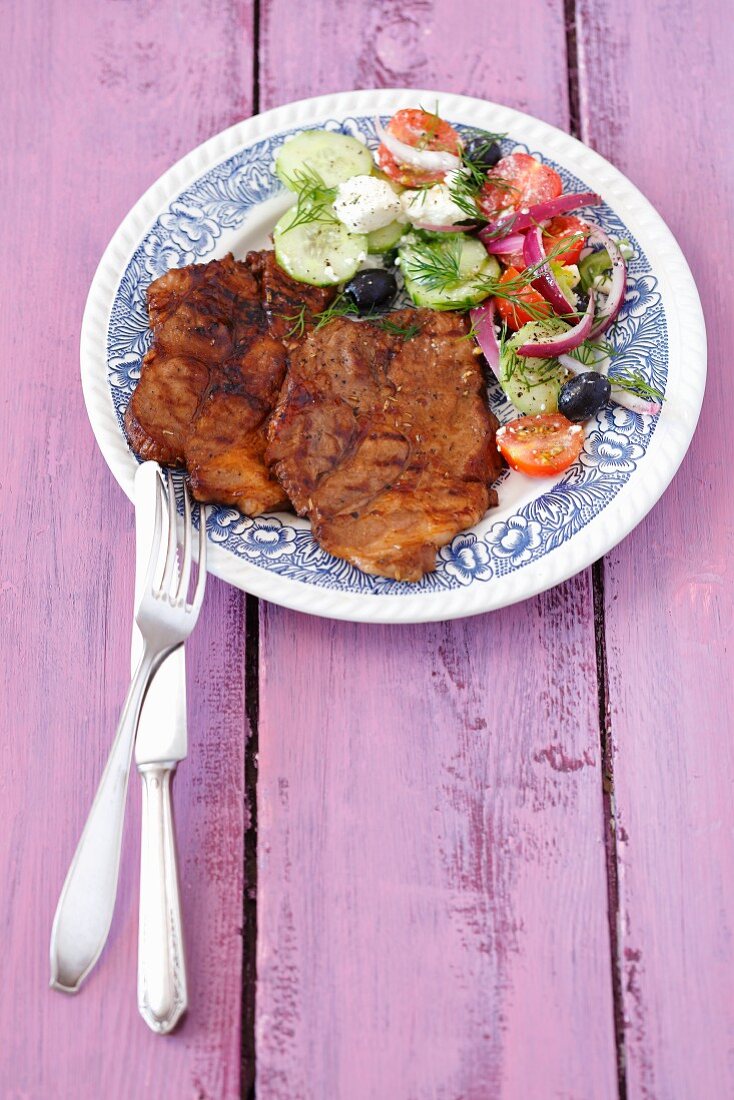 Grilled pork collar steaks with Greek salad