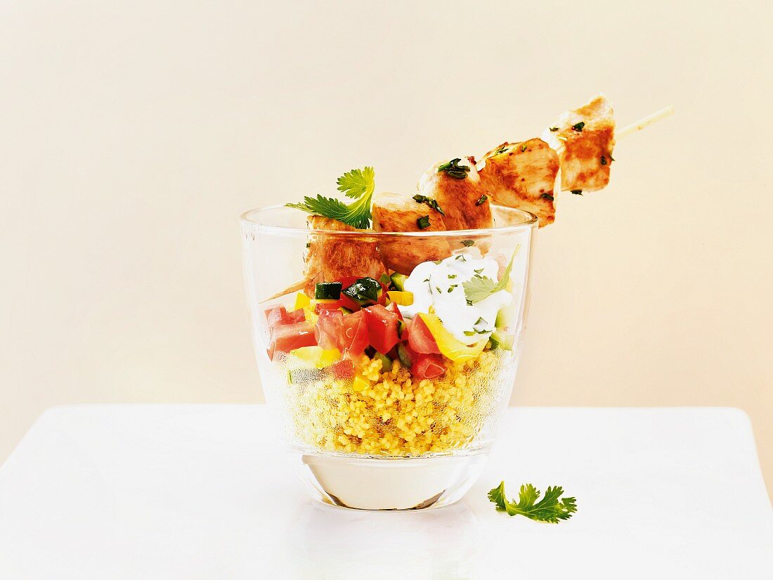 Chicken kebabs on a couscous salad served in a glass
