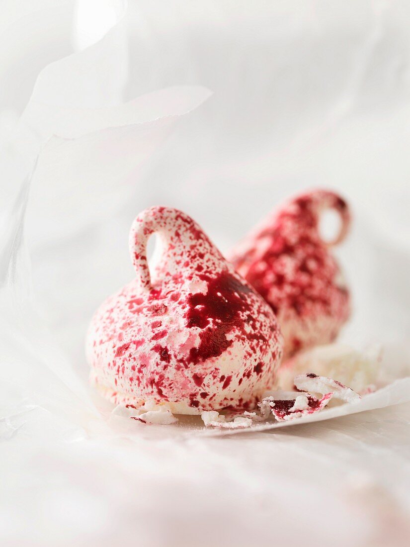 Two meringue kisses sprinkled with red