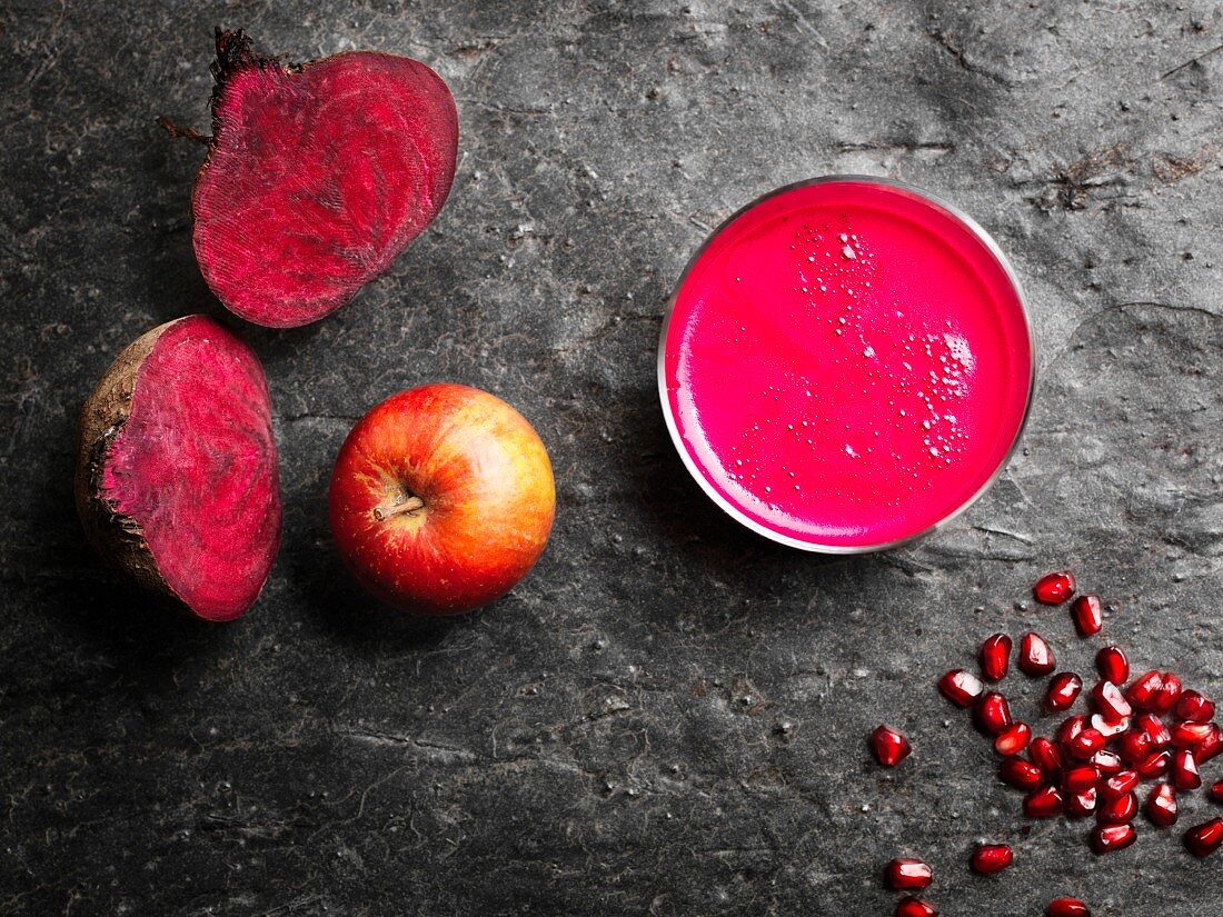 A pink superfood smoothie made with beetroot, apples and pomegranate seeds