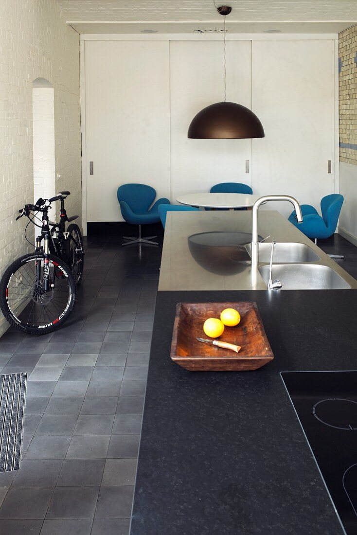 Island counter, dining area and sliding doors in long narrow kitchen