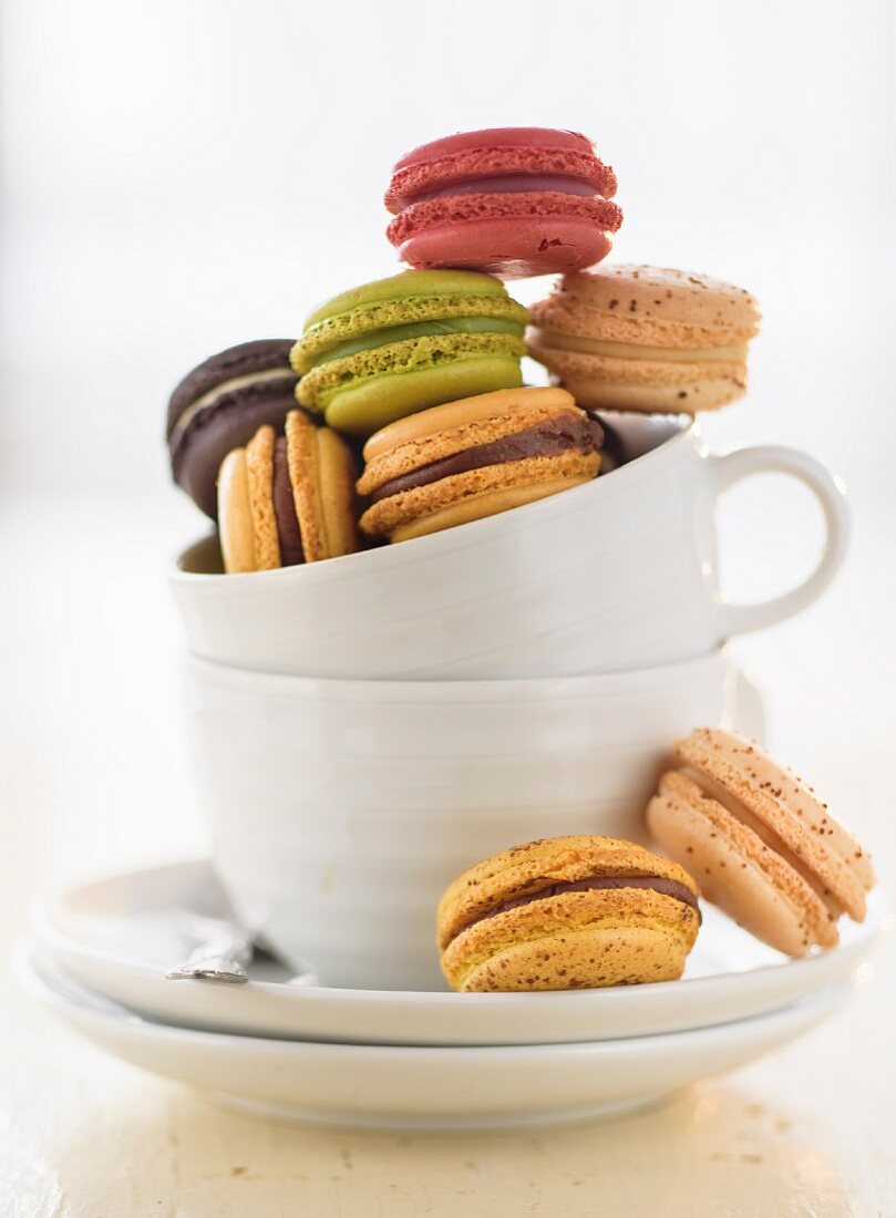 Various different coloured macaroons in a coffee cup