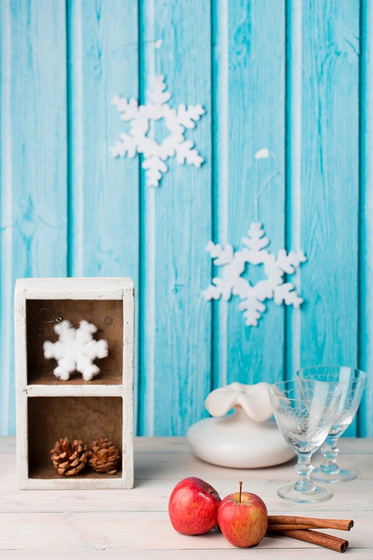 A winter arrangement featuring apples, cinnamon, pine cones and decorative snowflakes