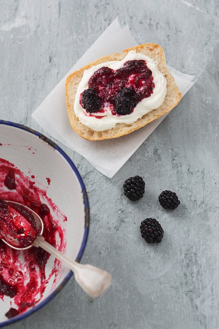 A roll spread with quark and homemade blackberry jam