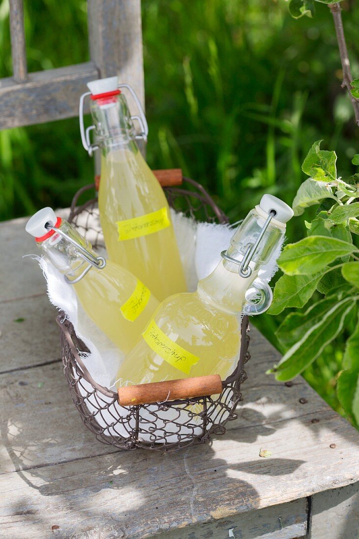 Homemade lemon syrup flip-top jars on a table outside