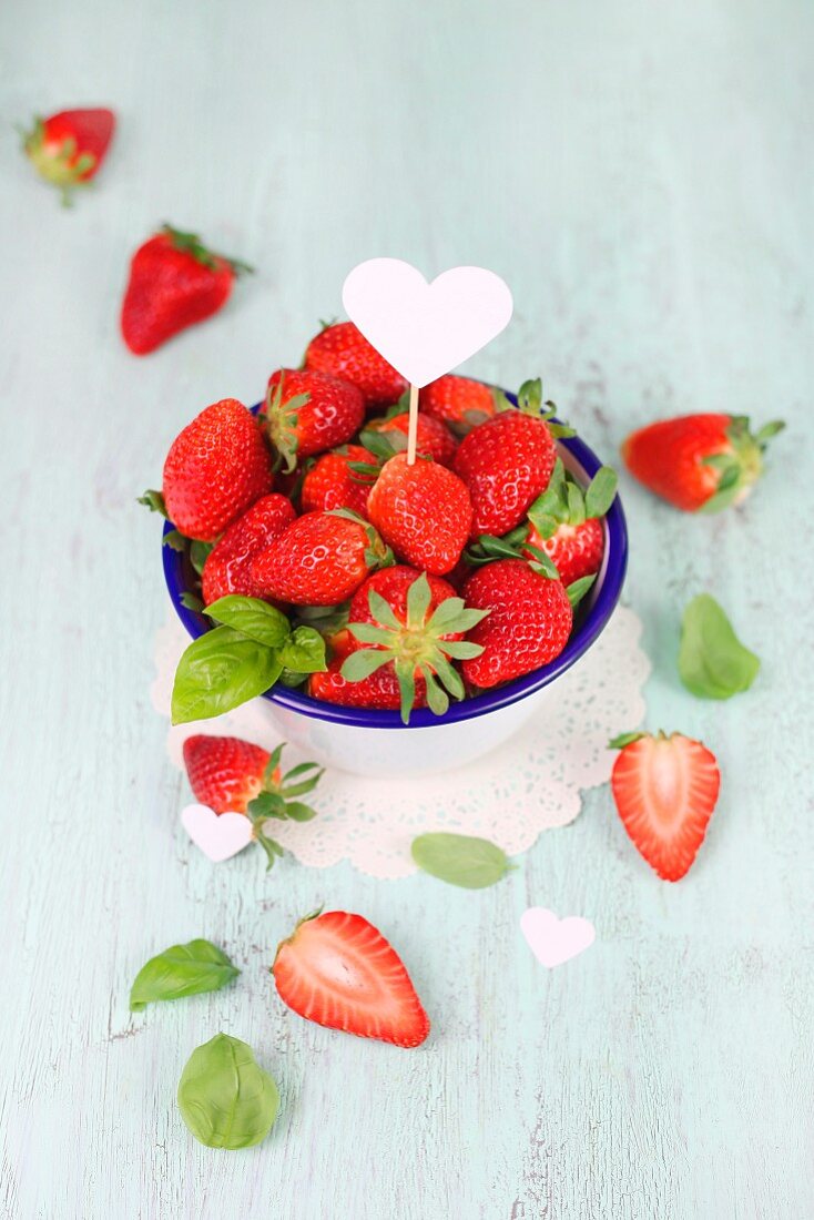Frische Erdbeeren mit Herzsticker und Basilikum