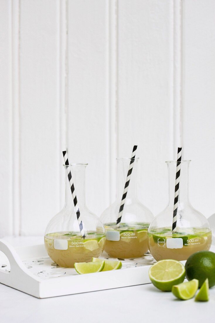 Lemonade with limes in carafes with straws