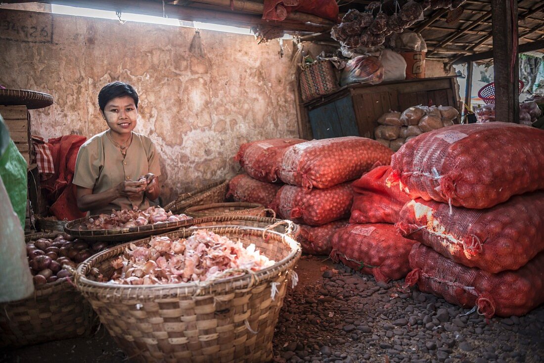 Frau schält Zwiebeln auf Hsipaw-Markt (Myanmar, Burma)