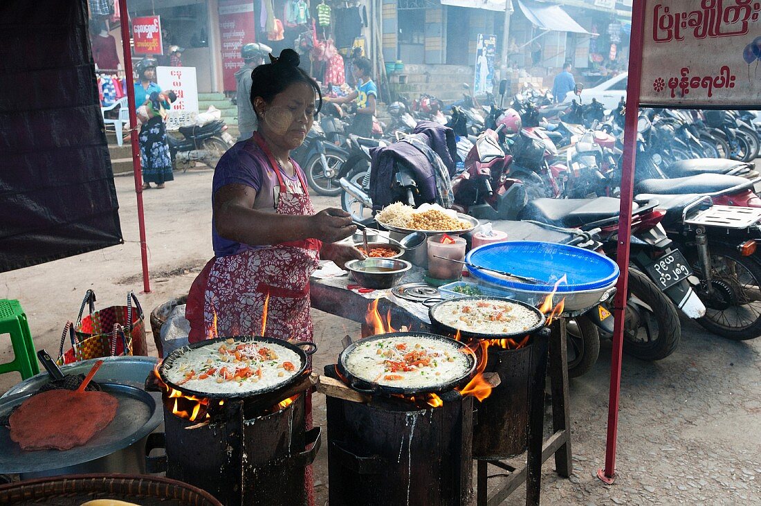 The woman preparing rice pancakes in a street kitchen (Myanmar, Burma)