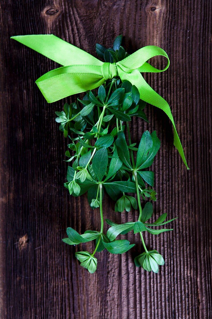 Woodruff tied with a bow on a wooden surface