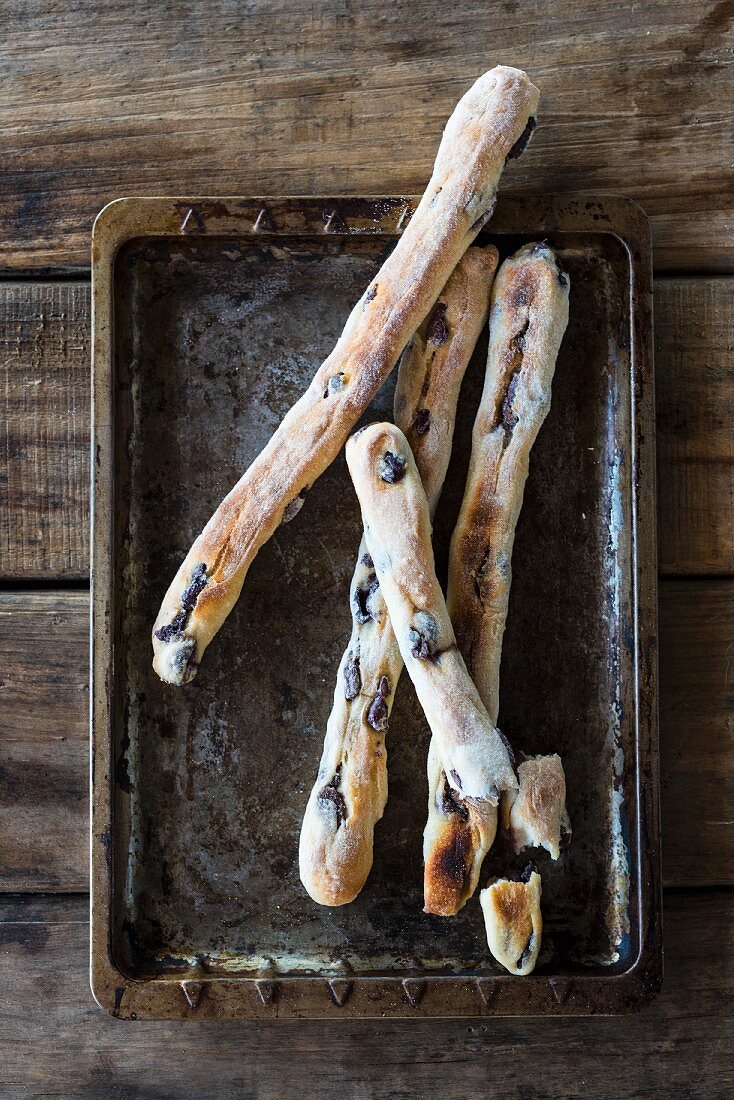 Olive breadsticks on an old baking tray