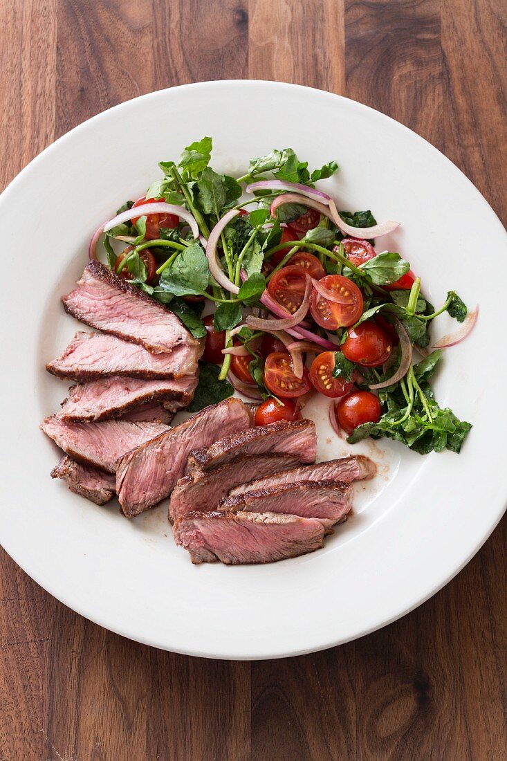 Kurzgebratenes Steak mit Brunnenkresse-Tomaten-Salat (Draufsicht)