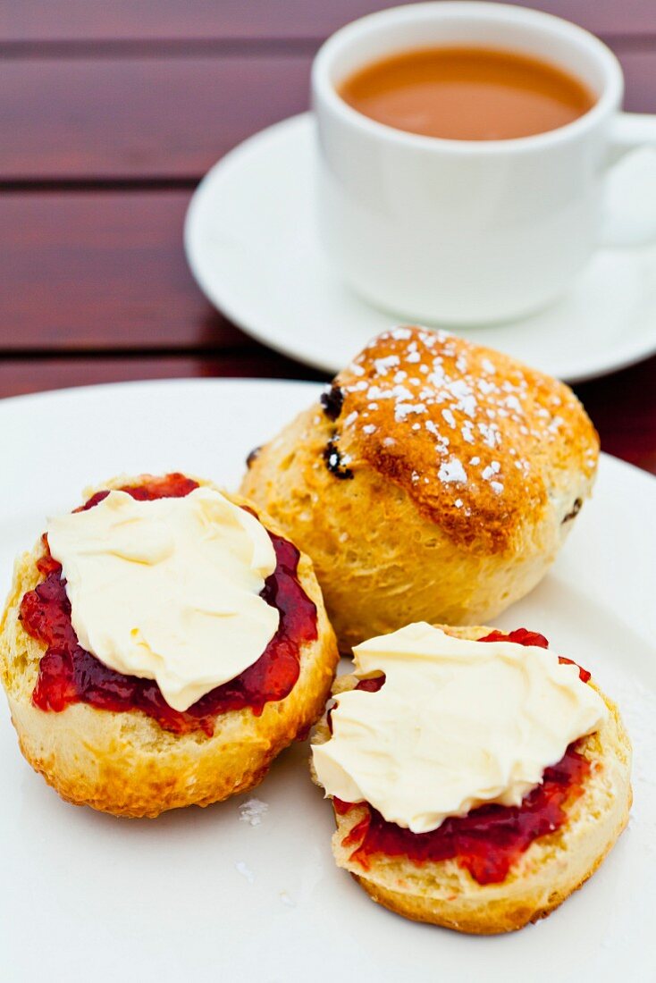 Scones with strawberry jam and clotted cream served with tea (England)