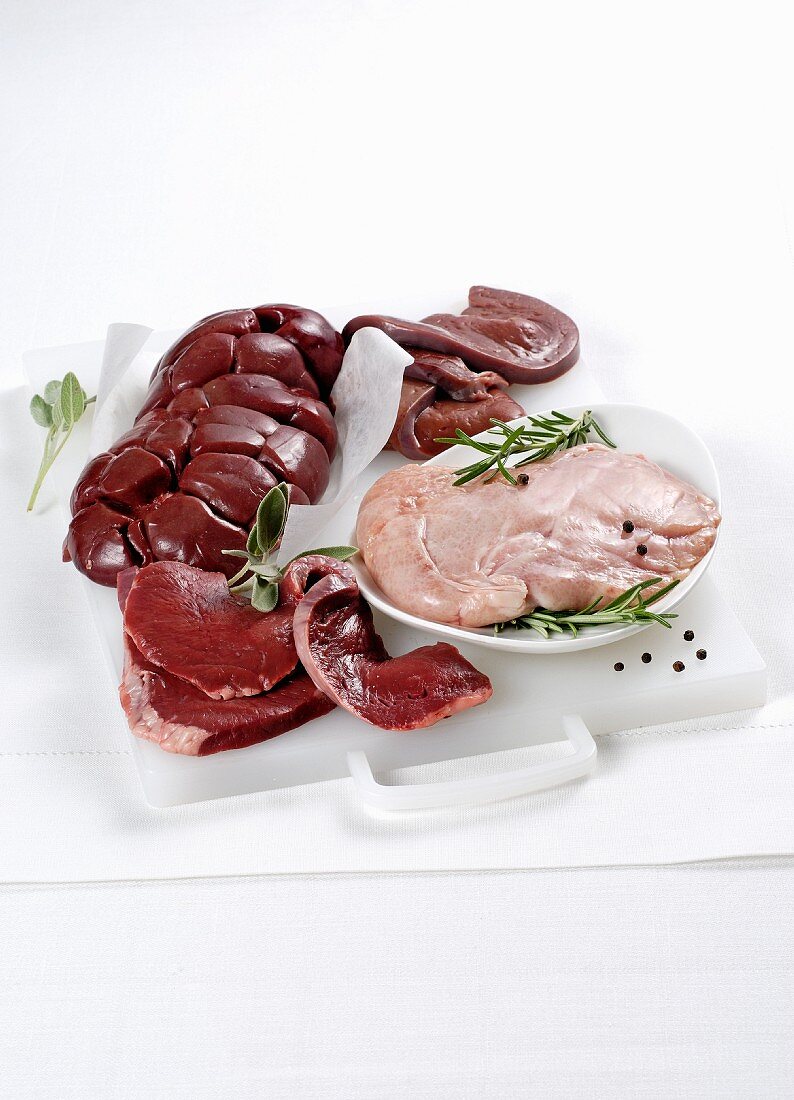 Veal innards, sage and rosemary on a white chopping board