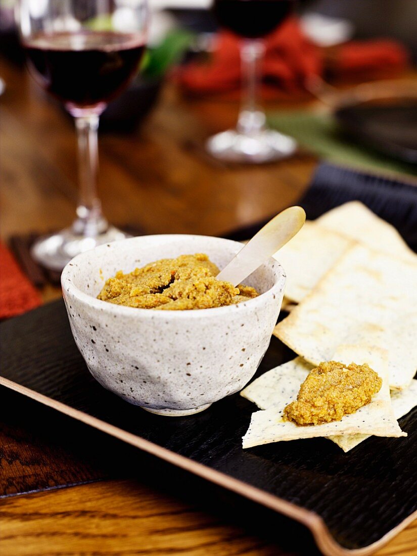 Tapenade aus grünen Oliven und getrockneten Tomaten mit Crackers