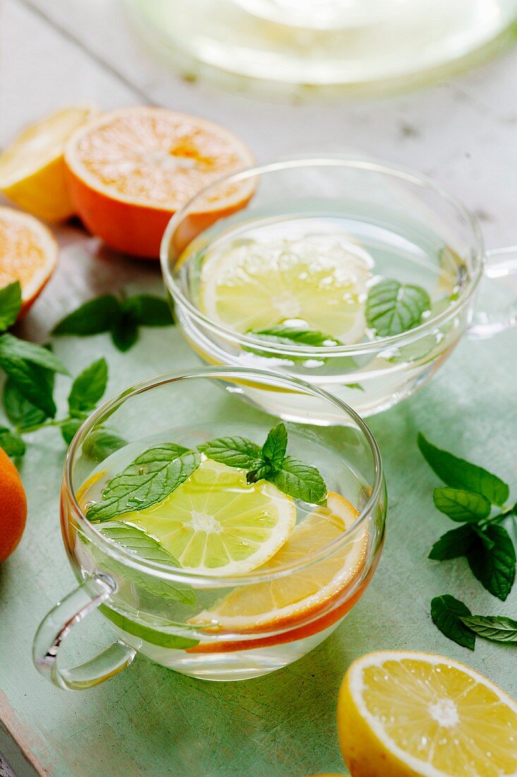 Citrus fruit tea with mint in glass cups