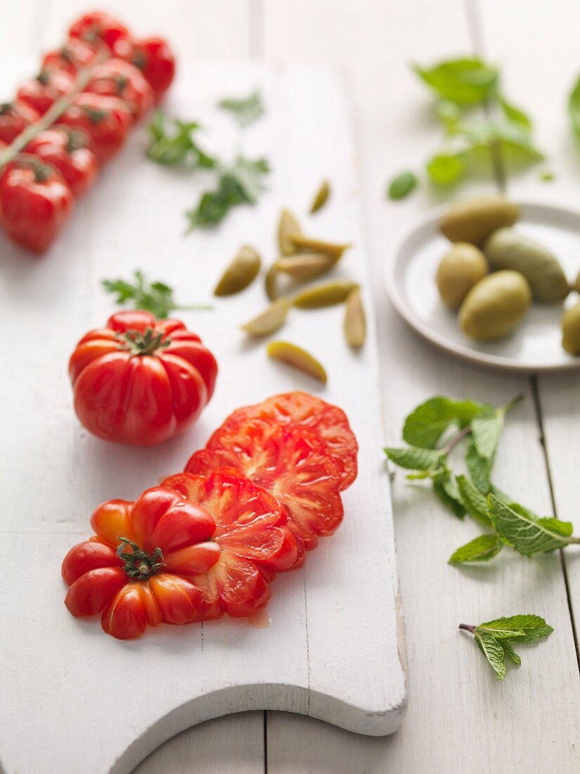 Tomaten und Oliven, ganz und geschnitten