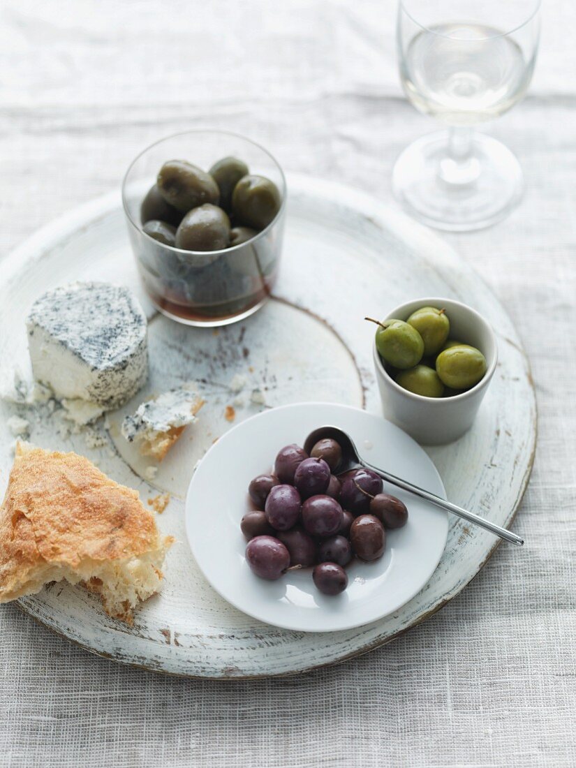 Verschiedene Oliven, Ziegenkäse und Fladenbrot