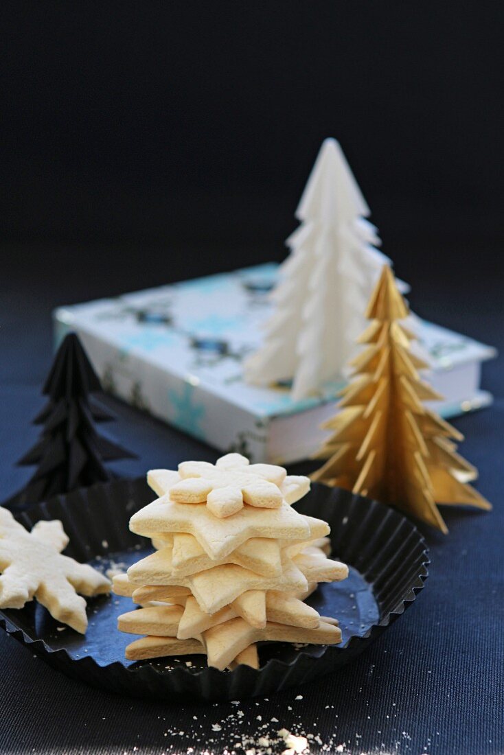 A pile of gluten-free Christmas biscuits with paper Christmas trees