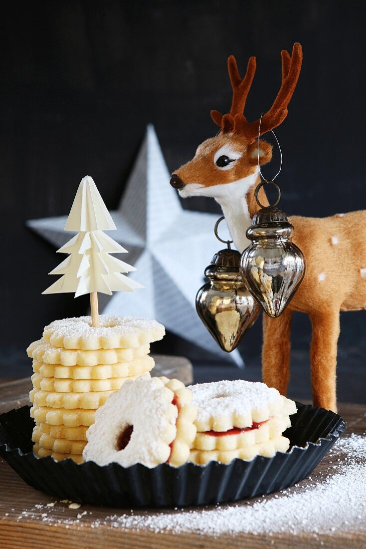 Stacked gluten-free Christmas Hildaplätzchen (jam-filled shortbread biscuits) with a reindeer and a white star