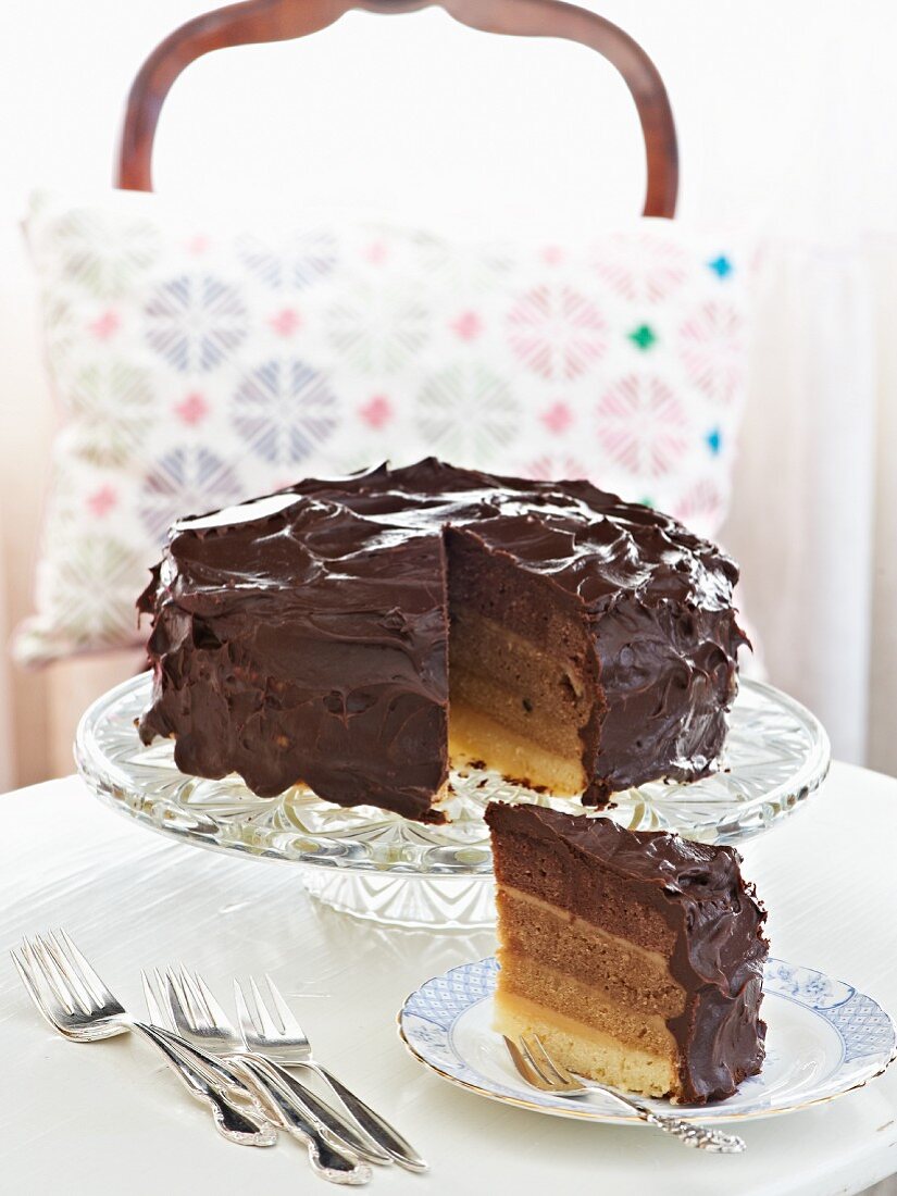A layered almond and chocolate cake with a slice cut out