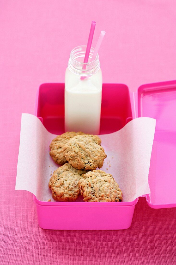 Haferflocken-Rosinen-Cookies und Milchflasche in Lunchbox