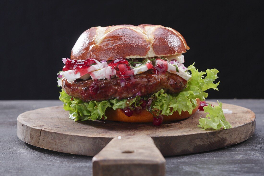 A steak burger on a wooden board