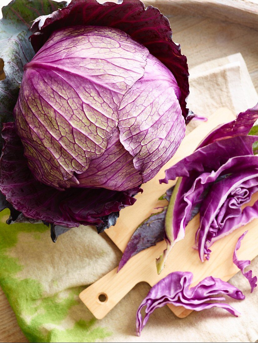 A fresh red cabbage, partially sliced