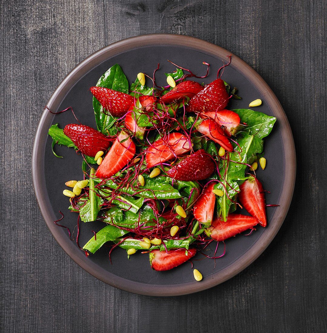 Löwenzahnsalat mit Erdbeeren, Rote-Bete-Sprossen und Pinienkernen