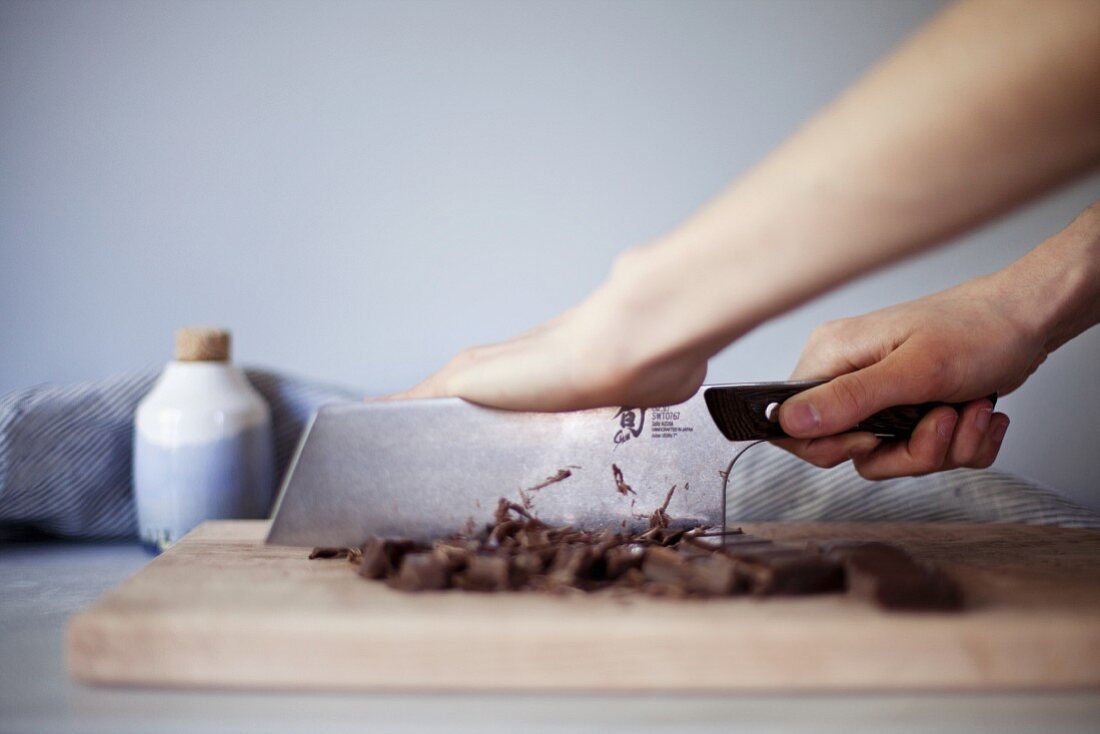 Chocolate being chopped to make salted caramel fudge sauce