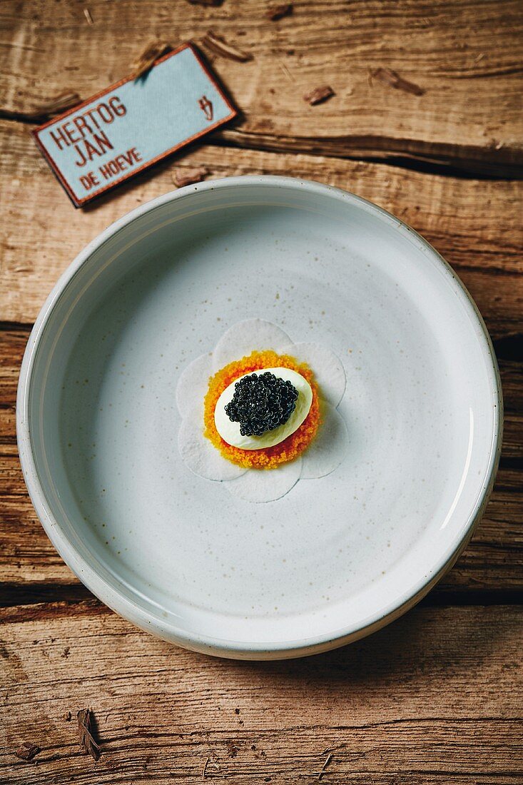 A dish of young turnip carpaccio with spring cheese and caviar, restaurant Less