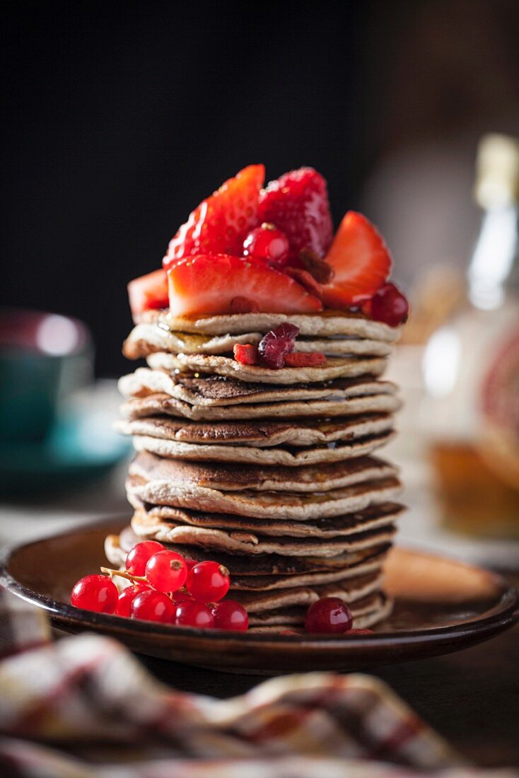 Gestapelte Pancakes mit Erdbeeren und Johannisbeeren