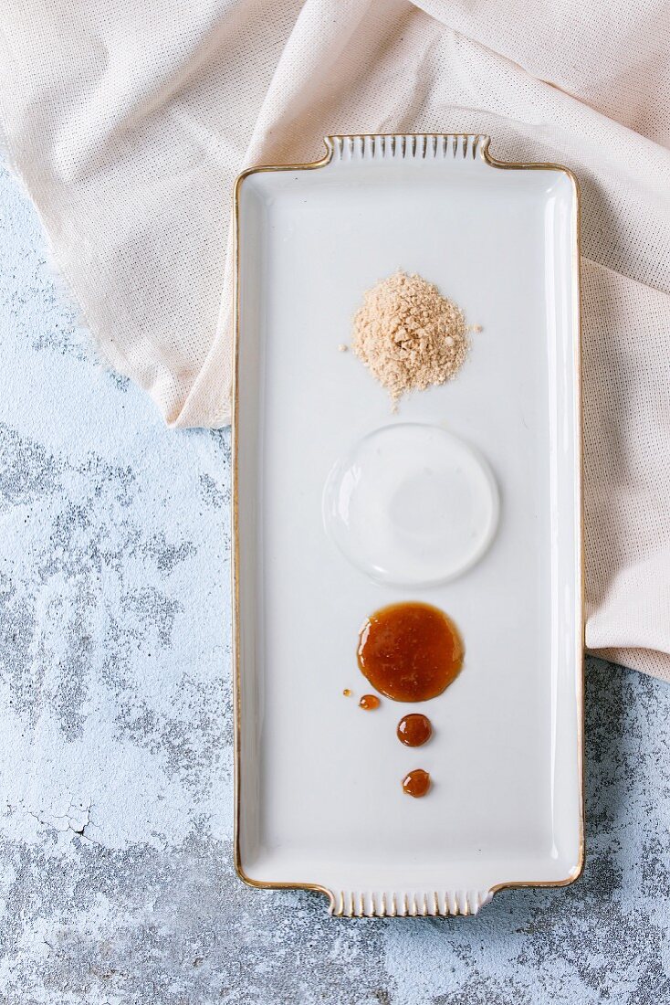 Raindrop cake with caramel sauce and fried flour on rectangular plate