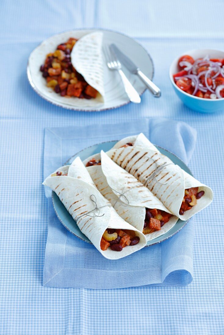 Tortilla rolls filled with pork, kidney beans and celery