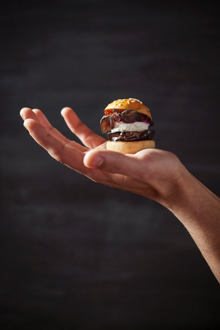 A mini veggie burger on a hand