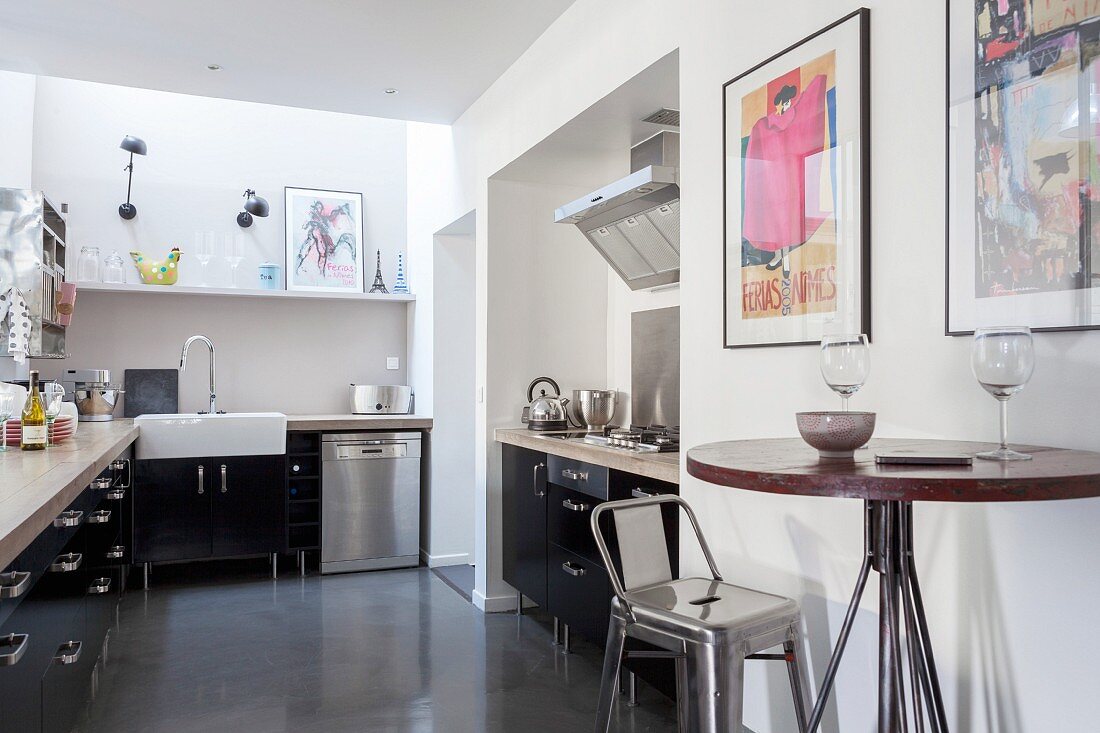 Black fitted kitchen with hob in niche