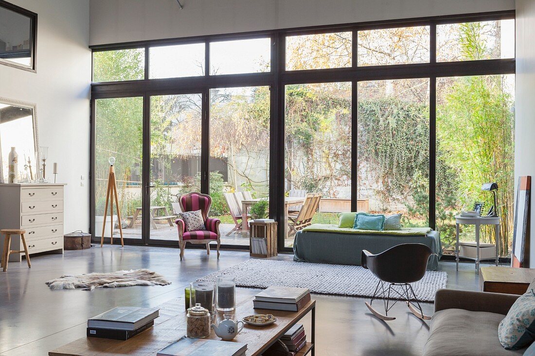 Fensterfront in offenem Stilmix-Wohnbereich mit Gartenblick