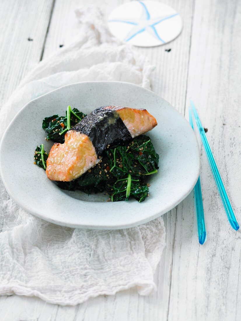 Salmon wrapped in nori on a bed of kale