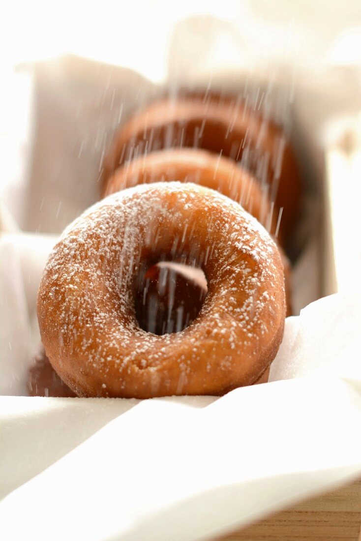 Doughnuts being sprinkled with sugar