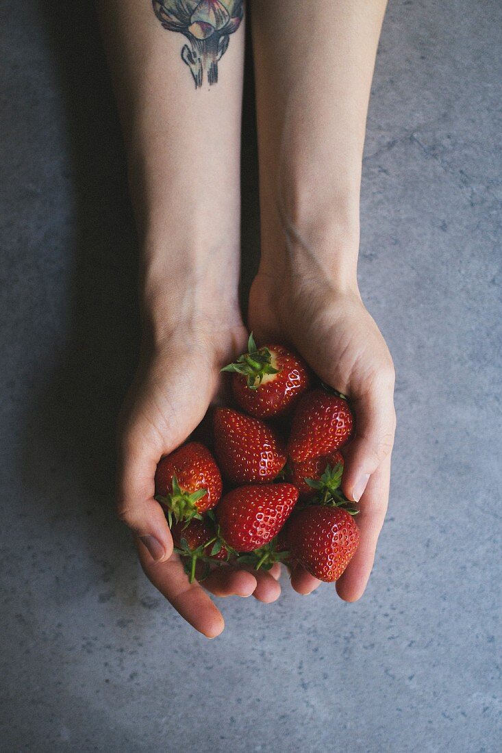Frauenhände halten Erdbeeren