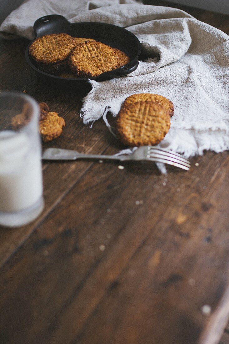 Frisch gebackene Cookies und Milch auf Holztisch