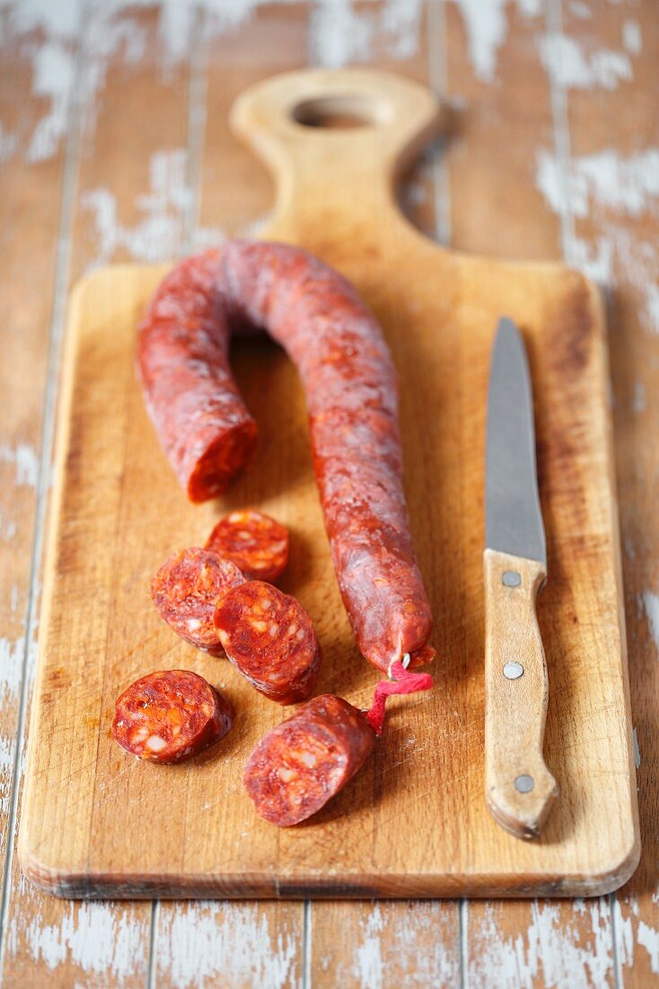 Chorizo on wooden board with a knife
