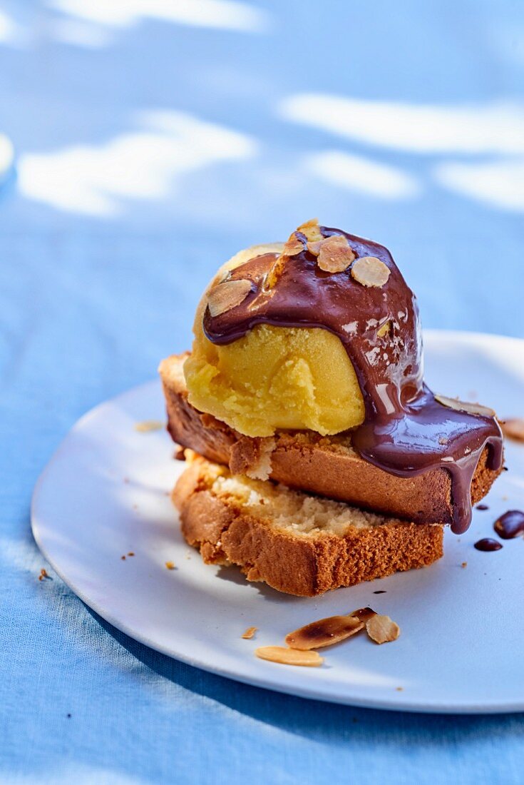 Mangoeis mit Schokoladensauce auf Kuchenstück