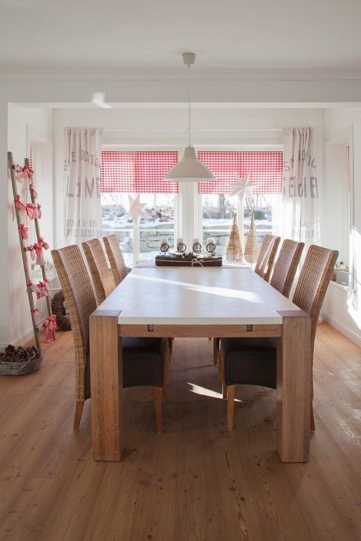 Solid wooden table and wicker chairs in festively decorated dining room