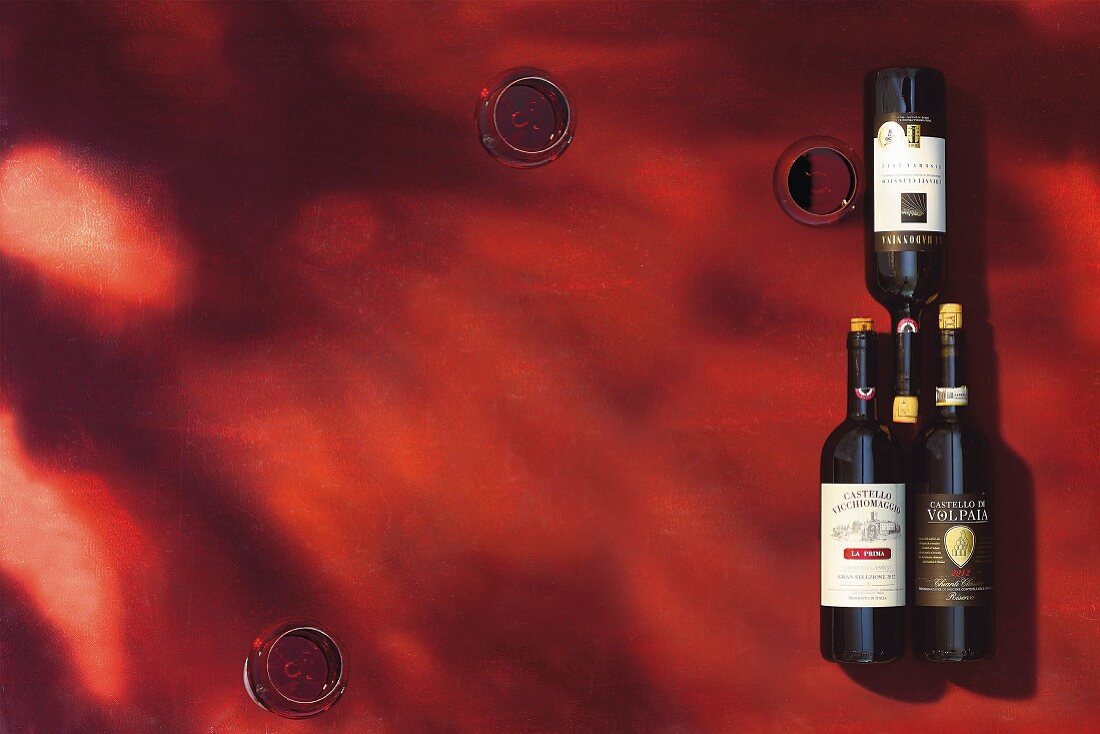 Mehrere Chianti Rotweine in Flaschen und Gläsern